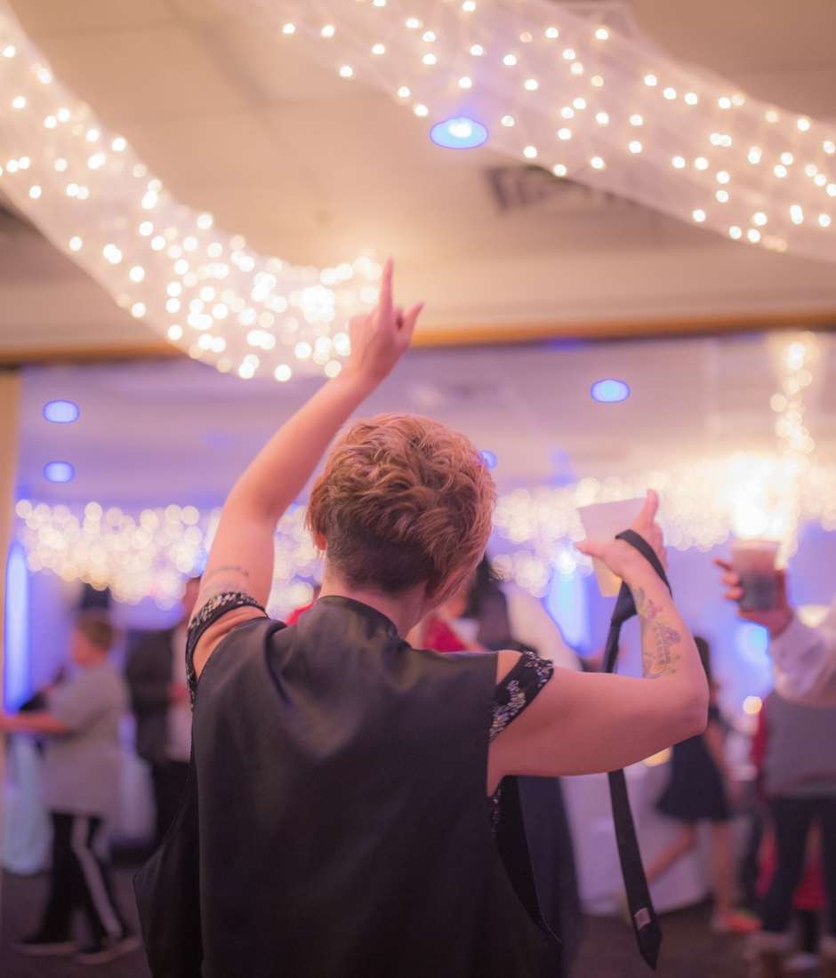 Guests celebrating on a lit reception dance floor